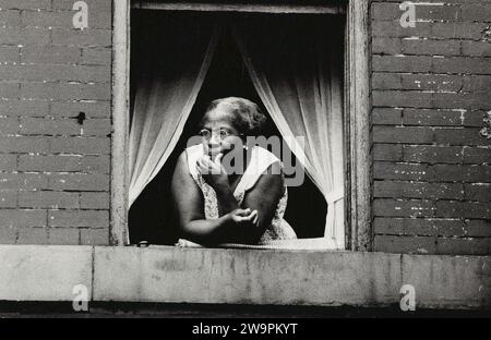 Donna che guarda fuori dalla finestra aperta dell'appartamento, New York City, New York, USA, Angelo Rizzuto, Anthony Angel Collection, agosto 1954 Foto Stock