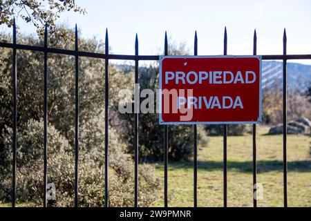 Traduzione: Proprietà privata. Cancello della barra di ferro su una recinzione in pietra a secco che dà accesso a un pascolo privato Foto Stock