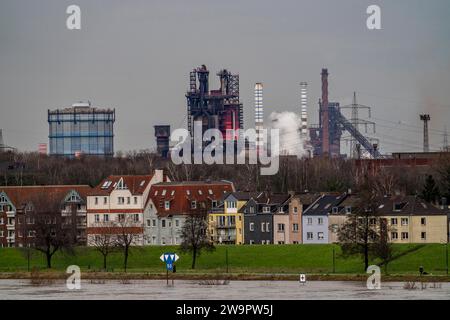 Reno vicino a Duisburg-Laar, case sulla strada diga, sfondo industriale delle acciaierie ThyssenKrupp a Bruckhausen, Flood, NRW, Germania, Foto Stock