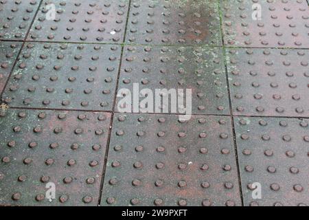 Una foto ravvicinata della pavimentazione tattile sul percorso. Foto Stock