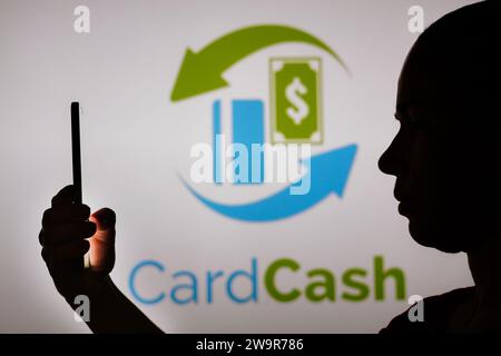 Brasile. 29 dicembre 2023. In questa foto, la silhouette di una donna contiene uno smartphone con il logo CardCash sullo sfondo. (Immagine di credito: © Rafael Henrique/SOPA Images via ZUMA Press Wire) SOLO USO EDITORIALE! Non per USO commerciale! Foto Stock