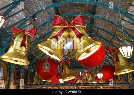 Luci natalizie al Covent Garden Market di Londra 2023 a forma di campane e nastri Foto Stock