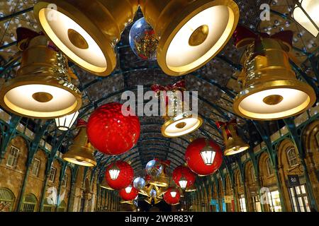 Luci natalizie al Covent Garden Market di Londra 2023 a forma di campane e nastri Foto Stock