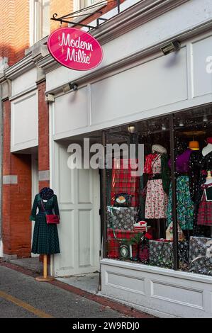 Salem, Massachusetts - Un negozio di abiti che espone abiti d'ispirazione vintage decorati per Natale con un cartello che legge Modern Millie si trova nello shado Foto Stock