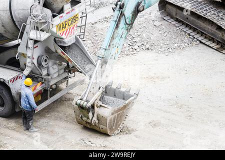 I tubi vengono innaffiati con dumper per cemento e escavatori Foto Stock