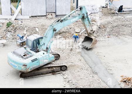 I tubi vengono innaffiati con dumper per cemento e escavatori Foto Stock