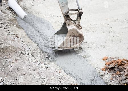 I tubi vengono innaffiati con dumper per cemento e escavatori Foto Stock
