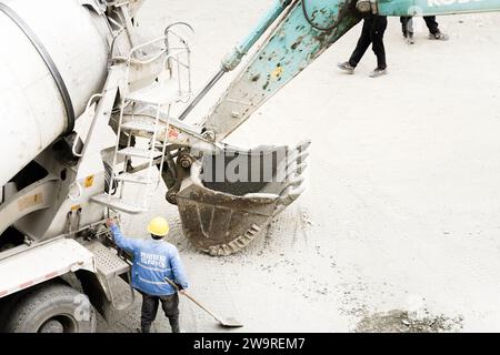I tubi vengono innaffiati con dumper per cemento e escavatori Foto Stock