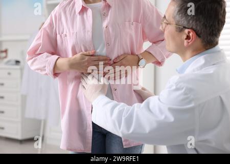 Gastroenterologo che esamina il paziente con dolore allo stomaco in clinica Foto Stock