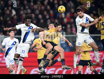 Genova, Italia. 29 dicembre 2023. Yann Bisseck dell'Inter (L, davanti) e Francesco Acerbi (R, davanti) gareggiano con il Genoa Radu Dragusin (C, davanti) durante la partita di serie A italiana tra Genova e FC Inter a Genova, 29 dicembre 2023. Credito: Augusto Casasoli/Xinhua/Alamy Live News Foto Stock