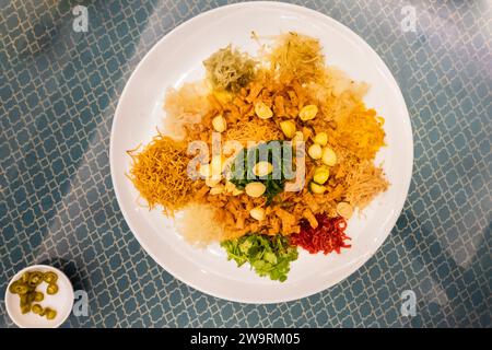 Servizio di yusheng o yee di buon auspicio cantato con abalone nel ristorante durante la celebrazione del capodanno cinese Foto Stock