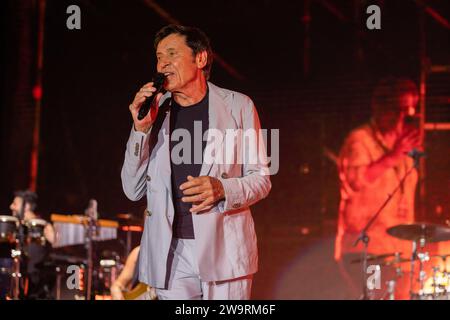 Gianni Morandi si esibisce dal vivo sul palco dell'Arena dei Pini di Baia Domizia. Foto Stock