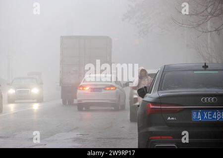 ANYANG, CINA - 30 DICEMBRE 2023 - le persone viaggiano nella nebbia pesante con visibilità inferiore a 200 metri nella contea di Hua, nella città di Anyang, provincia di Henan, chi Foto Stock