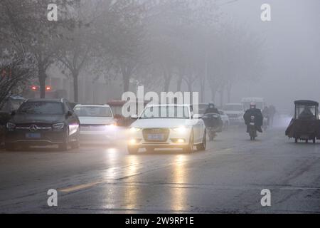 ANYANG, CINA - 30 DICEMBRE 2023 - le persone viaggiano nella nebbia pesante con visibilità inferiore a 200 metri nella contea di Hua, nella città di Anyang, provincia di Henan, chi Foto Stock