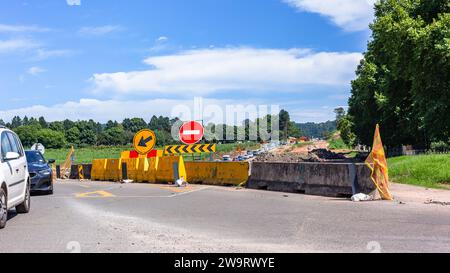 Veicoli ingorghi stradali segnaletica segnaletica segnaletica stradale ampliamento lavori stradali deviazione avanti. primo piano barriere gialle Foto Stock