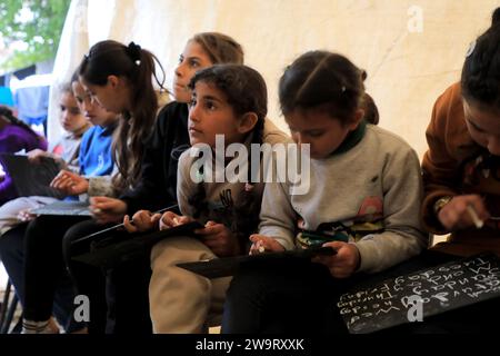 Pechino, Cina. 28 dicembre 2023. Gli studenti studiano in un'aula temporanea nella città di Rafah, nella Striscia di Gaza meridionale, il 28 dicembre 2023. Alcuni studenti di Gaza sono passati a studiare in aule temporanee, in quanto molte scuole qui sono utilizzate per accogliere i senzatetto inflitti da un nuovo ciclo di conflitti israelo-palestinese. Crediti: Rizek Abdeljawad/Xinhua/Alamy Live News Foto Stock