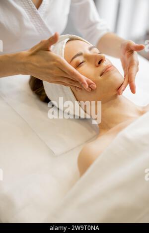 Donna che riceve un massaggio facciale rilassante Foto Stock