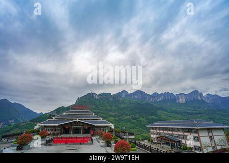 Centro visitatori con montagne maestose e un cielo spettacolare sullo sfondo. Enshi Grand Canyon Qixingzhai Scenic area, Enshi City, Hubei, Cina. Foto Stock