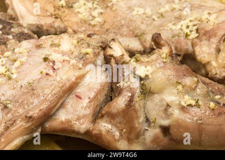 Un primo piano di succulenti pezzi di agnello stagionato appena tostato, marinato con un mix di erbe aromatiche e spezie, che ne esaltano la consistenza e j Foto Stock