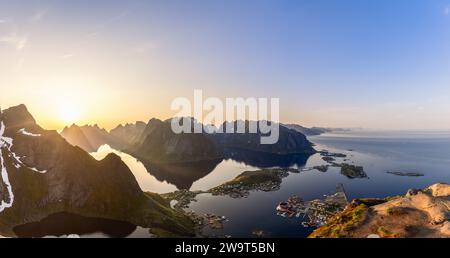 Il sole di mezzanotte proietta il suo bagliore etereo su un super panorama visto da Reinebringen; una prospettiva grandangolare mostra le sensazionali vette delle Lofoten surro Foto Stock