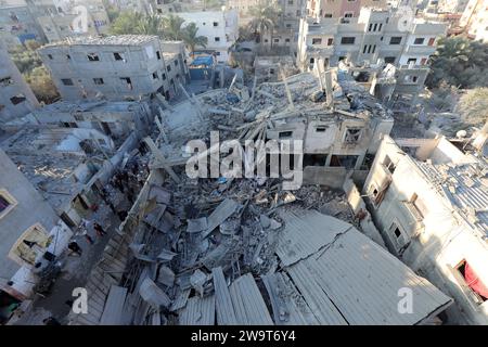 I residenti e le squadre di difesa civile conducono operazioni di ricerca e salvataggio sotto le macerie a seguito di un attacco israeliano i residenti e le squadre di difesa civile conducono operazioni di ricerca e salvataggio sotto le macerie a seguito di un attacco israeliano all'edificio della famiglia al-Wawi nel campo di Nuseirat, Striscia di Gaza, il 30 dicembre 2023. Foto di Naaman Omar apaimages Nuseirat Striscia di Gaza territorio palestinese 301223 Nusairat NAA 002 Copyright: XapaimagesxNaamanxOmarxxxapaimagesx Foto Stock