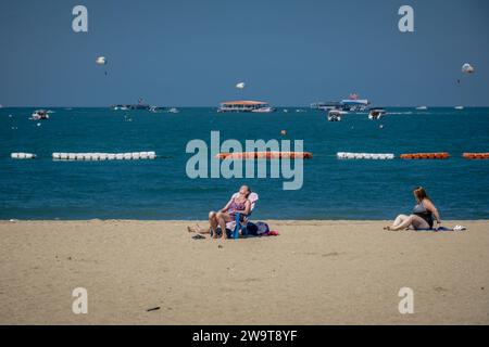 Pattaya, Thailandia. 27 dicembre 2023. Le donne occidentali si vedono prendere il sole sulla spiaggia di Pattaya. La spiaggia di Pattaya è una rinomata destinazione turistica in Thailandia. Ma mentre la città di Pattaya si è guadagnata una reputazione per la sua vivace vita notturna e le opzioni di intrattenimento, non è focalizzata esclusivamente sul servizio di ristorazione per viaggiatori singoli maschi. Oltre alla sua vita notturna, la città attrae diversi turisti, tra cui famiglie, coppie e individui di tutte le età, per lo shopping, le attività acquatiche e il relax sul mare. (Foto di Nathalie Jamois/SOPA Images/Sipa USA) credito: SIPA USA/Alamy Live News Foto Stock