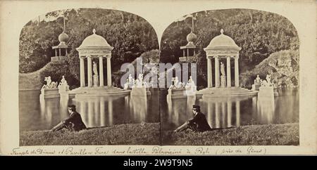 Uomo seduto presso uno stagno con il tempio di Diana e una pagoda (a sinistra) presso la Villa Pallavicini a Pegli, c. 1860 - c. 1880 stereografo carta di Pegli. supporto fotografico. giardino stampato con albumi di cartone. tempio, santuario  religione romana. tempio, santuario  induismo, Buddismo, Giainismo. Casa estiva, porto, casa-giardino (olandese: 'Theekoepel') Pegli. Villa Durazzo-Pallavicini Foto Stock