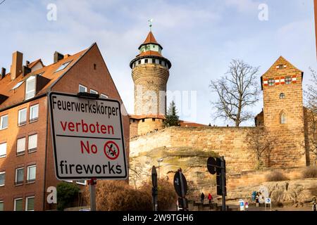 Zweisprachiges Hinweisschild für das Feuerwerksverbot in der Nürnberger Altstadt während der Silvesternacht in Deutsch und Englisch und dem Symbol mit durchgestricheneer Rakete und Böller. Hier am Burgberg vor der Kaiserburg. *** Segno bilingue per il divieto dei fuochi d'artificio nel centro storico di Norimberga durante la vigilia di Capodanno in tedesco e in inglese e il simbolo con un razzo barrato e dei petardi qui sul Burgberg di fronte al Castello Imperiale 20231230-6V2A6980 Foto Stock