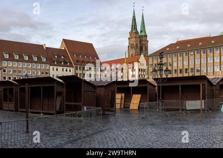 Leere Verkaufsstände nach dem Christkindlesmarkt auf dem Nürnberger Hauptmarkt. IM Hntergrund die Türme der Sebalduskirche und der schöne Brunnen. *** Bancarelle vuote dopo il mercatino di Natale sulla piazza principale del mercato di Nurembergs sullo sfondo, le torri di San Chiesa di Sebalds e la bella fontana 20231230-6V2A6959 Foto Stock