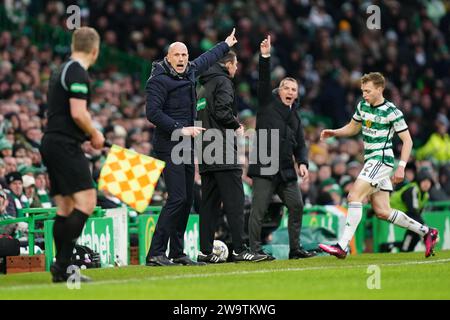 Il manager dei Rangers Philippe Clement (centro) e il manager dei Celtic Brendan Rodgers gestiscono la linea di contatto durante il Cinch Premiership match al Celtic Park, Glasgow. Data immagine: Sabato 30 dicembre 2023. Foto Stock