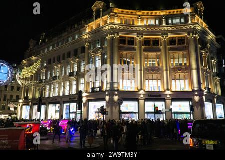Londra, Regno Unito. 29 dicembre 2023. Folle di venditori, taxi, autobus e pedicabs in prima serata all'Oxford Circus. Crediti: Anna Watson/Alamy Live News Foto Stock