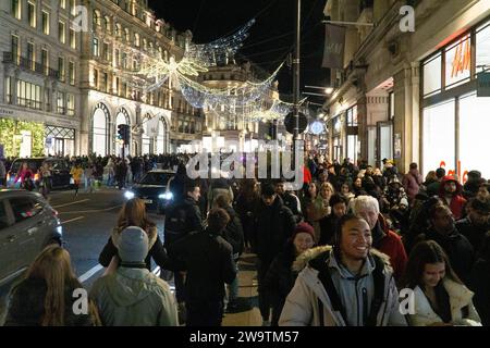 Londra, Regno Unito. 29 dicembre 2023. Folle di venditori in prima serata su Regent Street. Crediti: Anna Watson/Alamy Live News Foto Stock