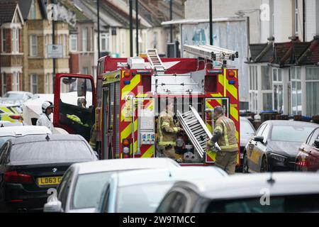 Vigili del fuoco e vigili del fuoco fuori da una proprietà in Sanderstead Road, Croydon, Londra sud, dove due uomini sono morti e altri due sono stati lasciati in condizioni critiche dopo un incendio di una casa il venerdì sera. Data immagine: Sabato 30 dicembre 2023. Foto Stock