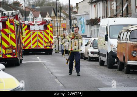 I vigili del fuoco sgomberano le attrezzature fuori da una proprietà in Sanderstead Road, Croydon, Londra sud, dove due uomini morirono e altri due furono lasciati in condizioni critiche dopo un incendio di casa il venerdì sera. Data immagine: Sabato 30 dicembre 2023. Foto Stock