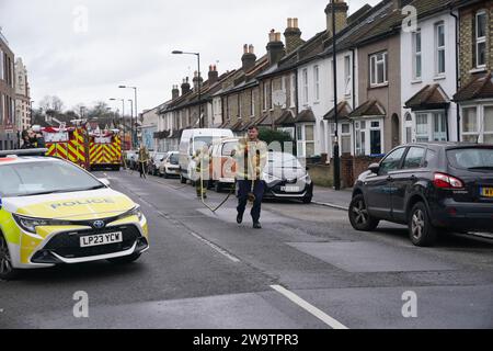 Vigili del fuoco fuori da una proprietà in Sanderstead Road, Croydon, Londra sud, dove due uomini morirono e altri due furono lasciati in condizioni critiche dopo un incendio di una casa il venerdì sera. Data immagine: Sabato 30 dicembre 2023. Foto Stock