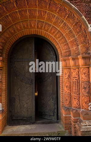 Regno Unito, Inghilterra, Surrey, Compton, 1898 Cemetery Chapel, esterno, decorazione in ceramica terracotta intorno alla porta Foto Stock