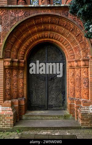 Regno Unito, Inghilterra, Surrey, Compton, 1898 Cemetery Chapel, esterno, decorazione in ceramica terracotta intorno alla porta Foto Stock