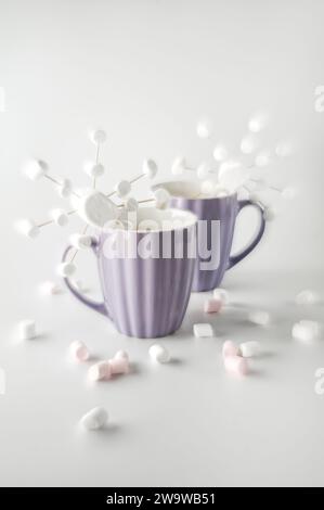 Tazze viola con caffè caldo e marshmallow. Due tazze con marshmallow a fiocco di neve. Effetto di messa a fuoco morbida. Foto Stock
