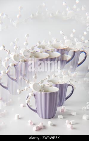 Tazze viola con caffè caldo e marshmallow. Due tazze con marshmallow a fiocco di neve. Effetto caleidoscopio. Foto Stock