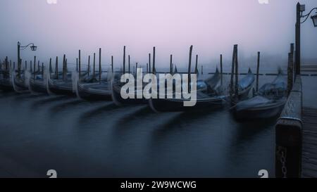 Una vista dal Palazzo Ducale, Venezia dall'altra parte dell'acqua a San Giorgio maggiore con le gondole in primo piano. Esposizione prolungata all'alba. Foto Stock