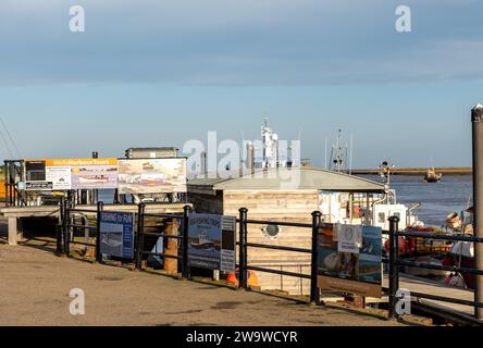 Wells-Next-the-SEA, Norfolk, Regno Unito - dicembre 29 2023. Pubblicità per gite di pesca e gite in barca nel molo e nel porto Foto Stock