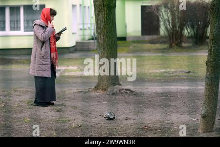 Non esclusiva: KIEV, UCRAINA - 29 DICEMBRE 2023 - Una donna si trova vicino al relitto di un missile russo, Kiev, capitale dell'Ucraina Foto Stock