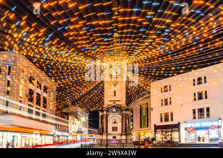 Brighton, East Sussex, Regno Unito, 30 dicembre 2023. La torre dell'orologio del Giubileo è incastonata dalle luci natalizie che sbiadono e soffiano in giro con il tempo tempestoso mentre il traffico circonda la zona e gli acquirenti sono alla ricerca di occasioni in questa trafficata città sulla costa sud.©Sarah Mott / Alamy Live News. Foto Stock