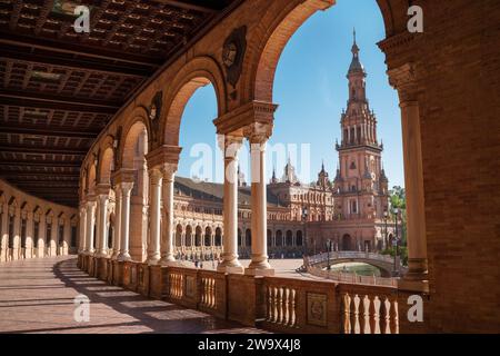 Le gallerie di Plaza de España si illuminarono con la luce del sole della sera creando ombre magiche. Vista della torre nord su Piazza Spagna, Andalusia, Spagna meridionale. Foto Stock