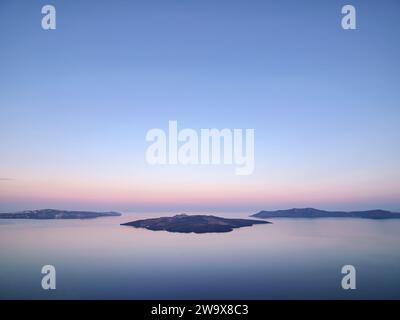 Vulcano Nea Kameni alla Caldera visto da Fira all'alba, Santorini o Thira, Cicladi, Grecia Foto Stock