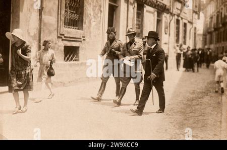 I gerarchi fascisti italiani passeggiano lungo una strada ad Asti, in Italia, alla fine degli anni trenta Foto Stock