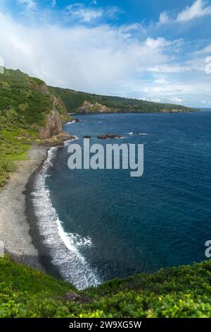 Uno splendido arco arcobaleno sul tranquillo Oceano Pacifico lungo la costa frastagliata di Maui, vista dall'autostrada Piilani. Foto Stock