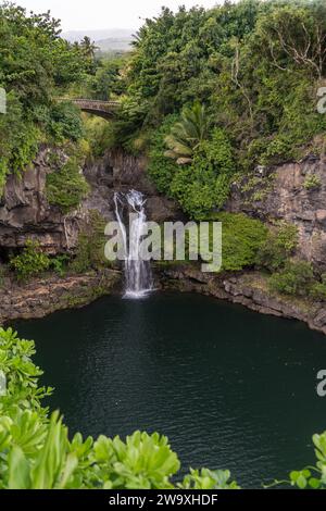 Una serena cascata si trasforma in una tranquilla piscina naturale, immersa nei lussureggianti paesaggi del Parco Nazionale di Haleakalā, nei pressi dell'autostrada Piilani. Foto Stock