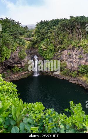 Una serena cascata si trasforma in una tranquilla piscina naturale, immersa nei lussureggianti paesaggi del Parco Nazionale di Haleakalā, nei pressi dell'autostrada Piilani. Foto Stock