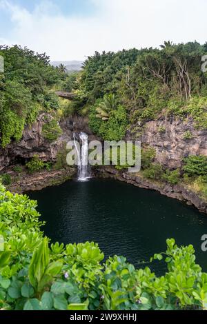 Una serena cascata si trasforma in una tranquilla piscina naturale, immersa nei lussureggianti paesaggi del Parco Nazionale di Haleakalā, nei pressi dell'autostrada Piilani. Foto Stock
